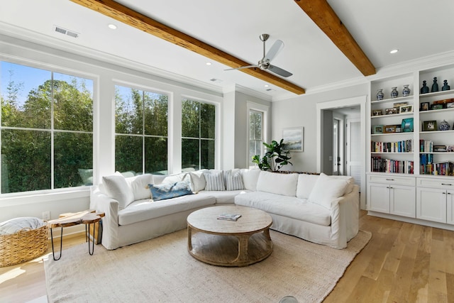interior space with crown molding, beam ceiling, light wood-style floors, a ceiling fan, and visible vents