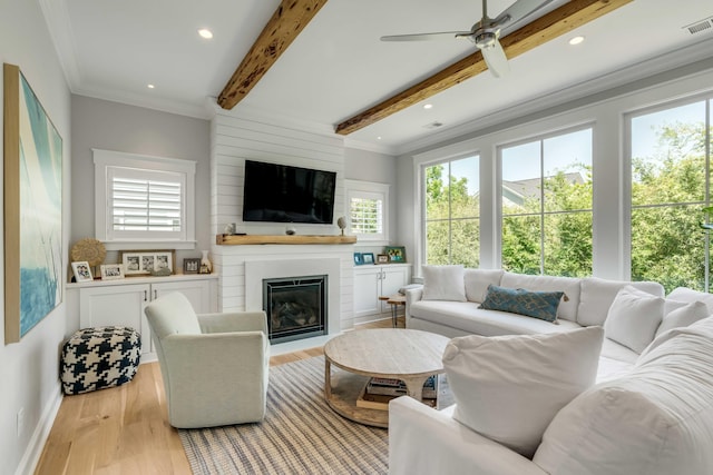 living room with beamed ceiling, plenty of natural light, and wood finished floors