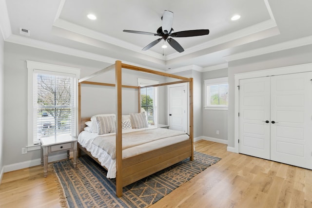 bedroom featuring baseboards, ceiling fan, recessed lighting, a tray ceiling, and light wood-style flooring