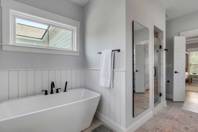 full bathroom featuring a soaking tub and a shower stall