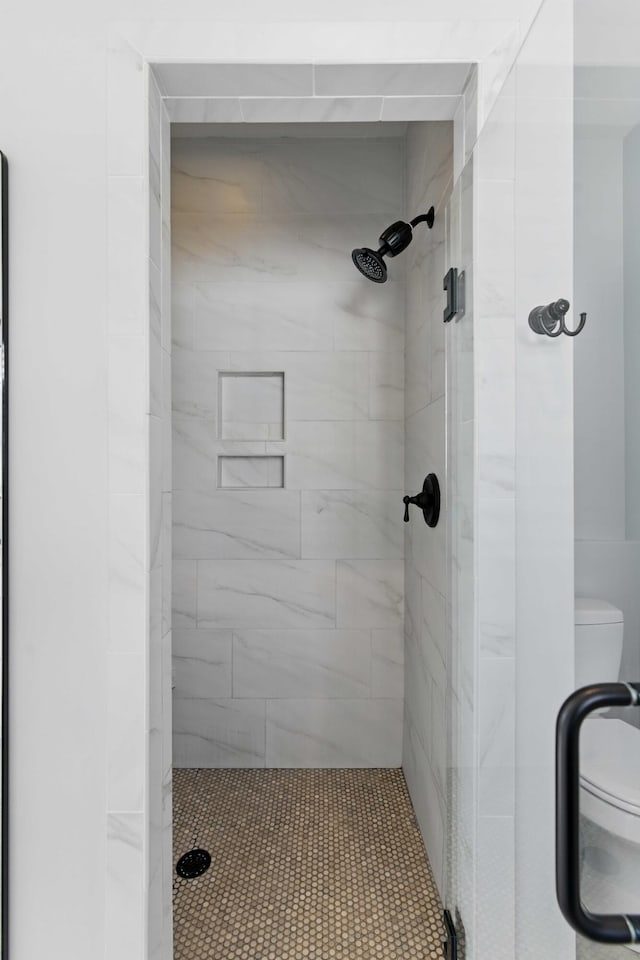full bathroom featuring toilet and a shower stall