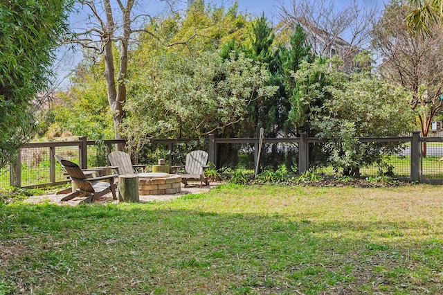 view of yard with fence and a fire pit