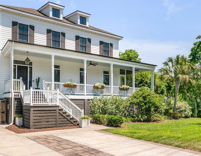 view of front of home with ceiling fan, covered porch, and stairway