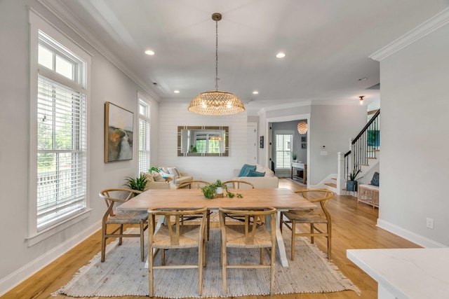 dining room with baseboards, ornamental molding, and stairs