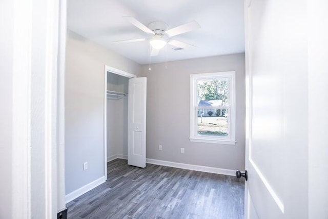 unfurnished bedroom with ceiling fan, dark hardwood / wood-style flooring, and a closet