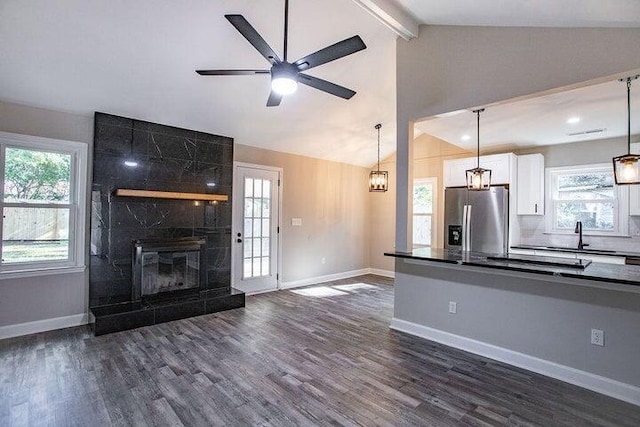 kitchen featuring white cabinetry, vaulted ceiling with beams, sink, dark hardwood / wood-style flooring, and stainless steel fridge with ice dispenser