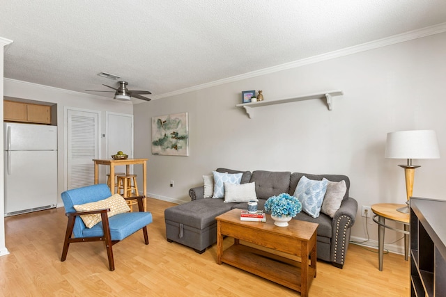 living area featuring crown molding, visible vents, and light wood-style floors