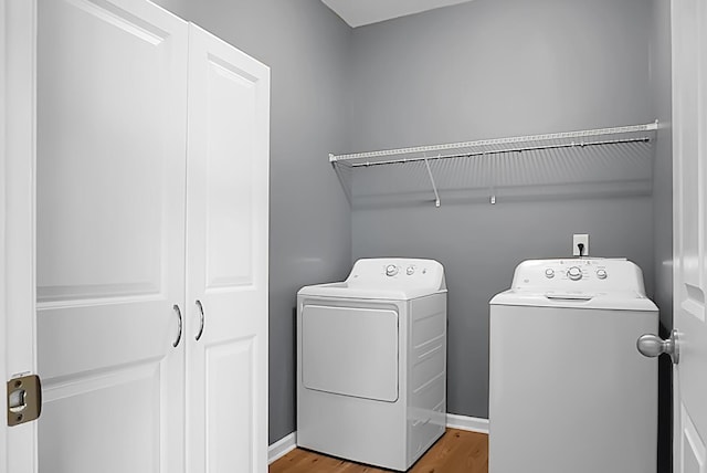 laundry room featuring hardwood / wood-style flooring and separate washer and dryer