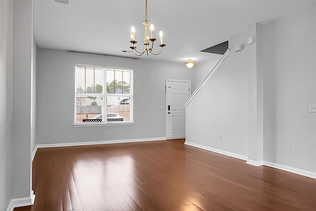 unfurnished dining area featuring wood-type flooring and a notable chandelier