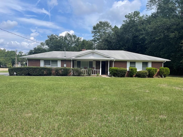 ranch-style home featuring a front lawn and covered porch