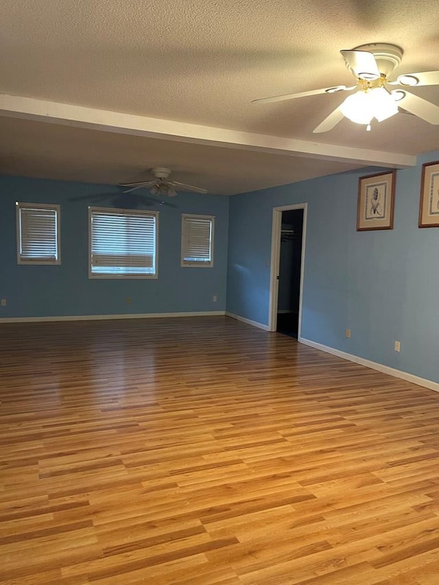 spare room with ceiling fan, a textured ceiling, and light wood-type flooring