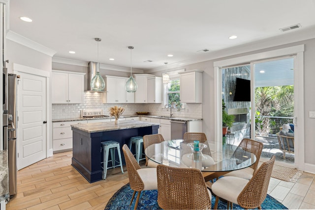 dining area featuring ornamental molding, light wood-style floors, visible vents, and recessed lighting