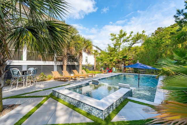 pool with fence, a patio, and an in ground hot tub