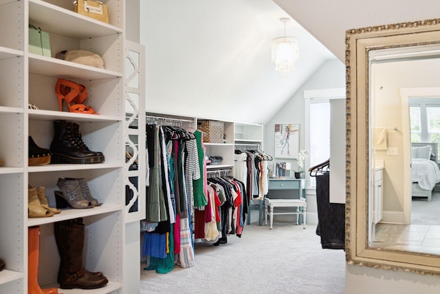 walk in closet with vaulted ceiling and carpet