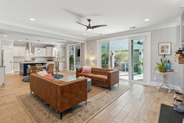 living room featuring light wood-type flooring, visible vents, recessed lighting, a ceiling fan, and ornamental molding