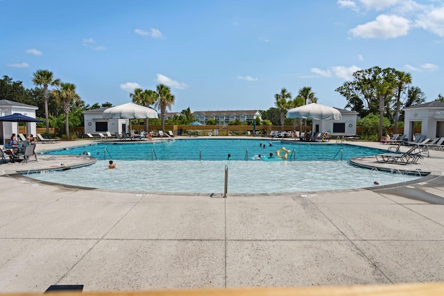 pool featuring fence and a patio