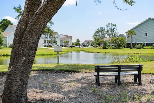 view of property's community with a yard, a residential view, and a water view