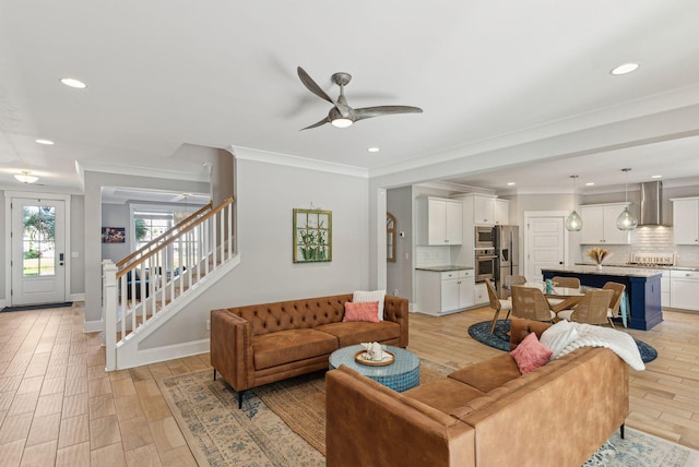living room featuring recessed lighting, light wood-style flooring, a ceiling fan, and stairs