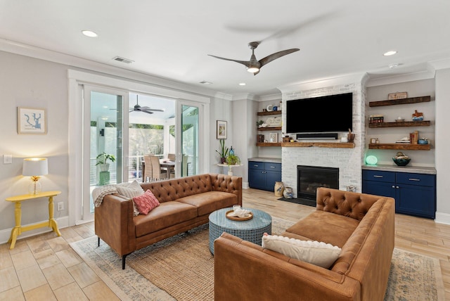 living room featuring light wood finished floors, visible vents, a brick fireplace, ceiling fan, and ornamental molding