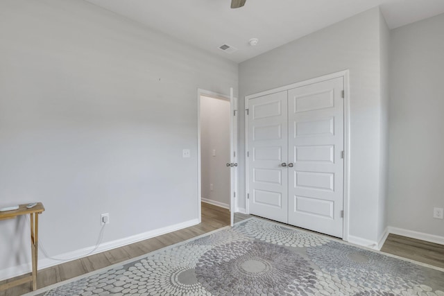 bedroom featuring hardwood / wood-style floors, ceiling fan, and a closet