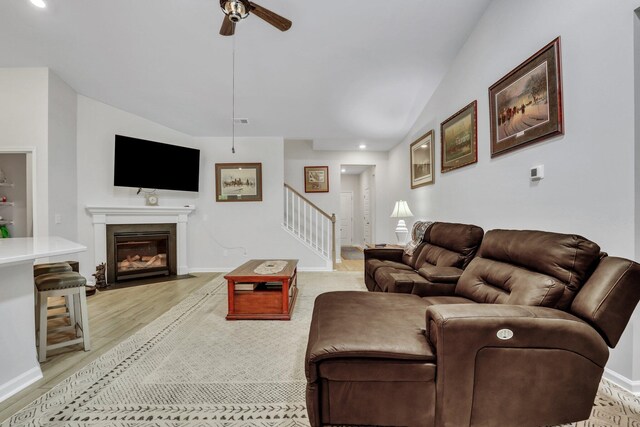 living room featuring vaulted ceiling, ceiling fan, and light hardwood / wood-style floors