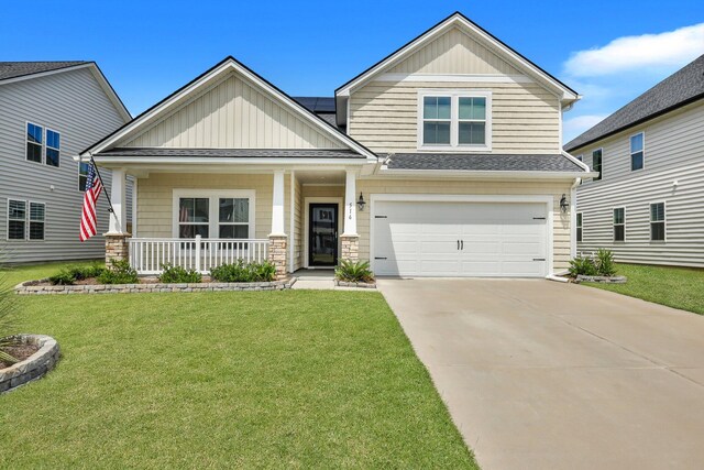 craftsman-style house with a garage, covered porch, and a front lawn