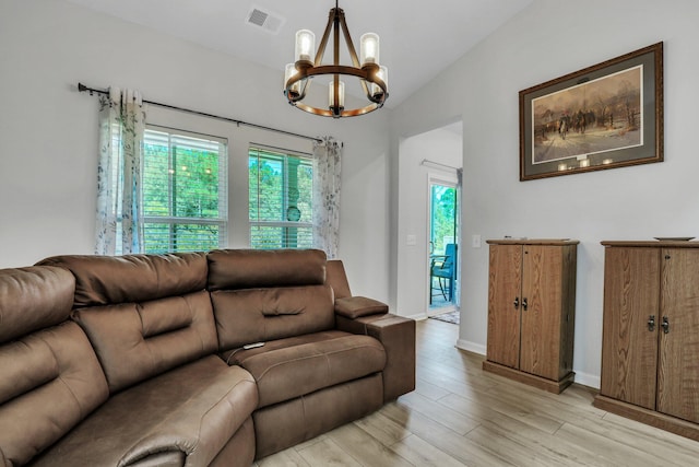 living room featuring light hardwood / wood-style flooring, a wealth of natural light, an inviting chandelier, and vaulted ceiling