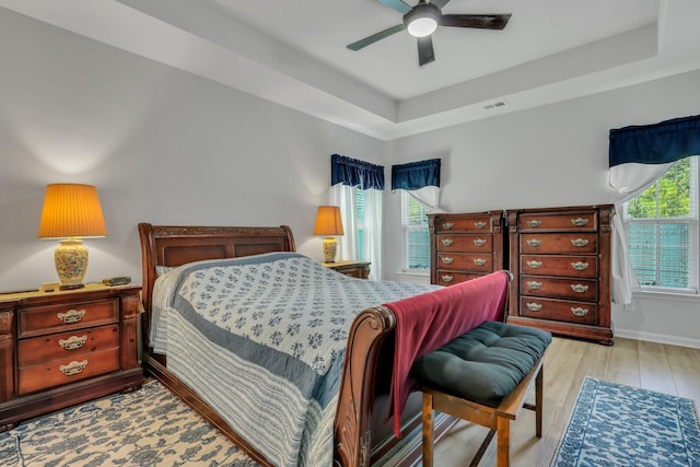 516 Yellow Leaf Ln, Summerville, SC 29486 - bedroom featuring multiple windows, a tray ceiling, and wood finished floors