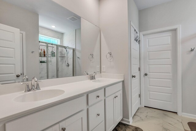 bathroom featuring a shower with door and vanity