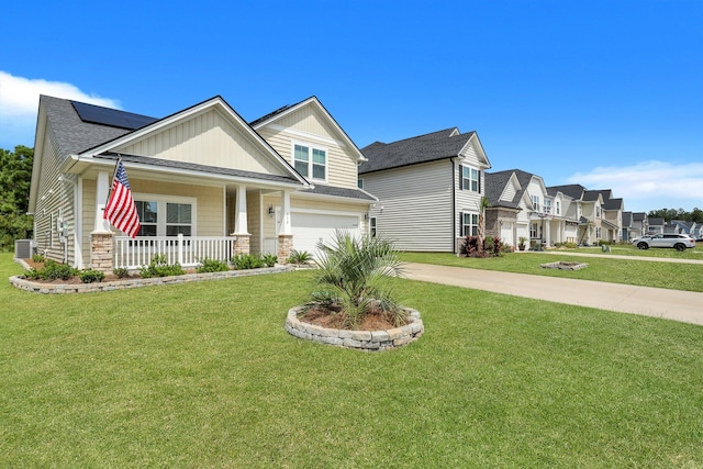 craftsman house featuring central air condition unit, a porch, a garage, and a front yard