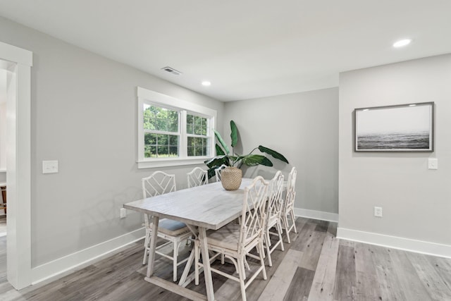 dining space with visible vents, baseboards, and wood finished floors