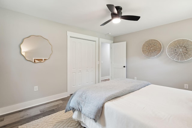 bedroom featuring a ceiling fan, baseboards, dark wood finished floors, and a closet