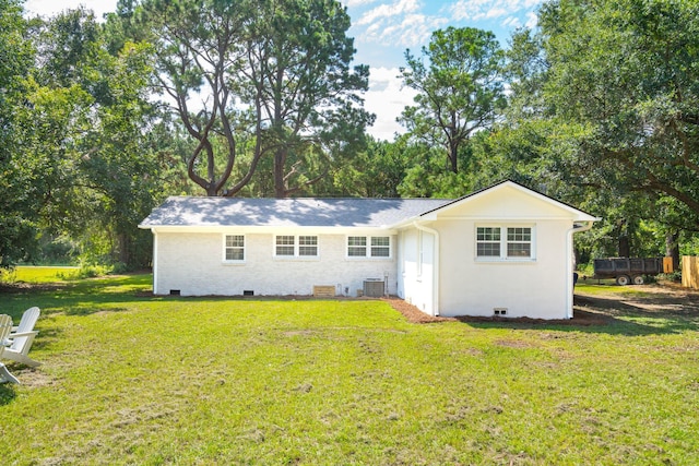 rear view of property featuring brick siding, crawl space, a lawn, and central air condition unit