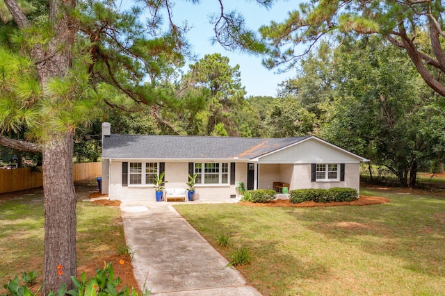 ranch-style house with brick siding, roof with shingles, a chimney, fence, and a front lawn