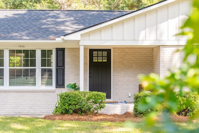 property entrance with brick siding, board and batten siding, and a shingled roof