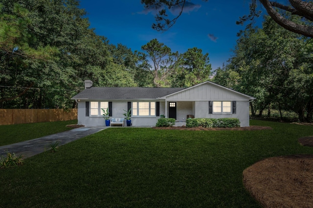 single story home with a chimney, fence, a front lawn, and board and batten siding