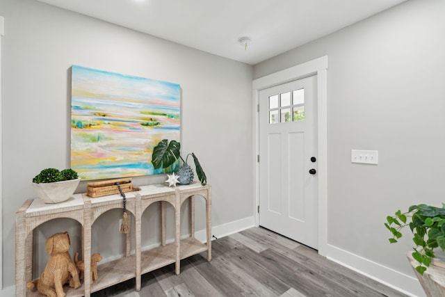 foyer entrance featuring light wood-style flooring and baseboards