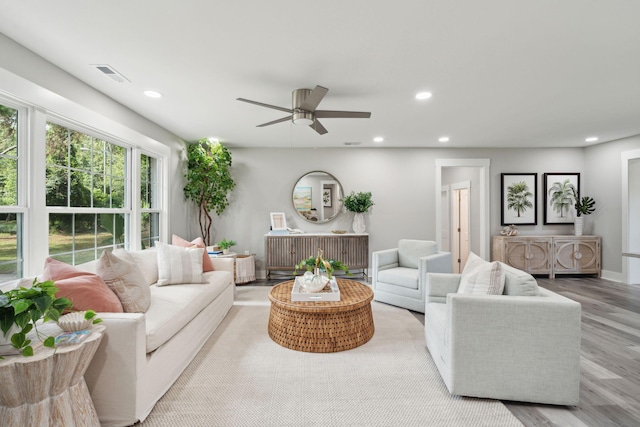 living room featuring baseboards, visible vents, a ceiling fan, light wood-style floors, and recessed lighting