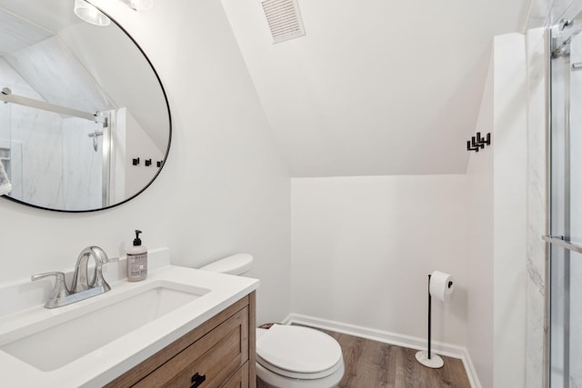 full bath with vaulted ceiling, a marble finish shower, toilet, visible vents, and wood finished floors