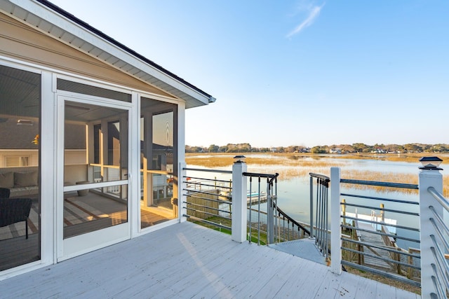 deck featuring a water view, a boat dock, and a sunroom