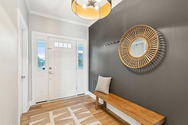 foyer featuring crown molding, wood finished floors, and baseboards