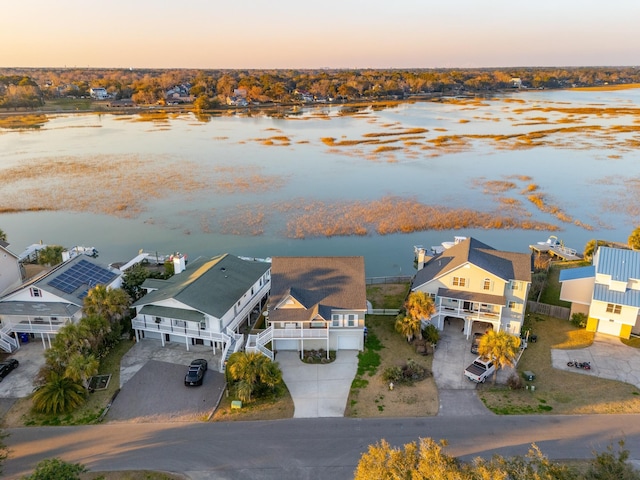 aerial view at dusk with a residential view and a water view