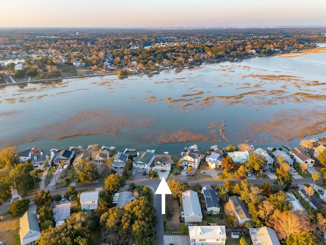 aerial view at dusk with a residential view and a water view