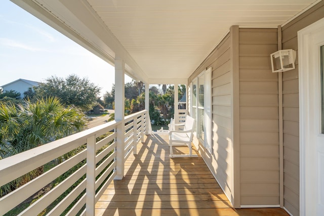deck featuring a porch and an AC wall unit