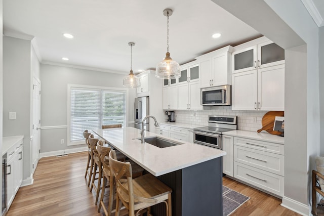 kitchen featuring decorative backsplash, a sink, ornamental molding, and stainless steel appliances
