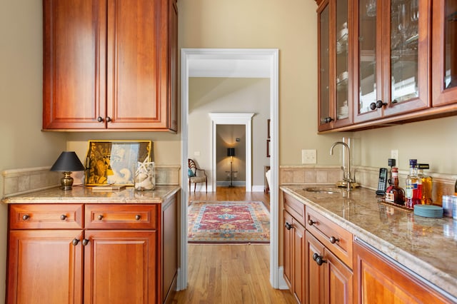 kitchen featuring light hardwood / wood-style flooring, sink, and light stone countertops