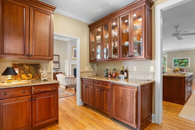 kitchen featuring crown molding, sink, ceiling fan, and light hardwood / wood-style floors