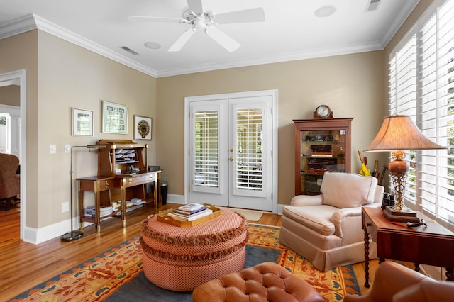 living area featuring ornamental molding, a wealth of natural light, ceiling fan, and light hardwood / wood-style floors