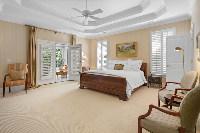 carpeted bedroom with ornamental molding, access to outside, a tray ceiling, and ceiling fan