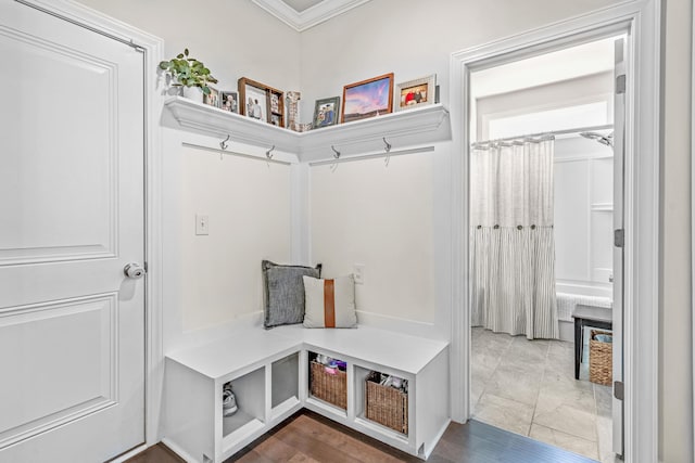 mudroom with tile patterned floors and crown molding